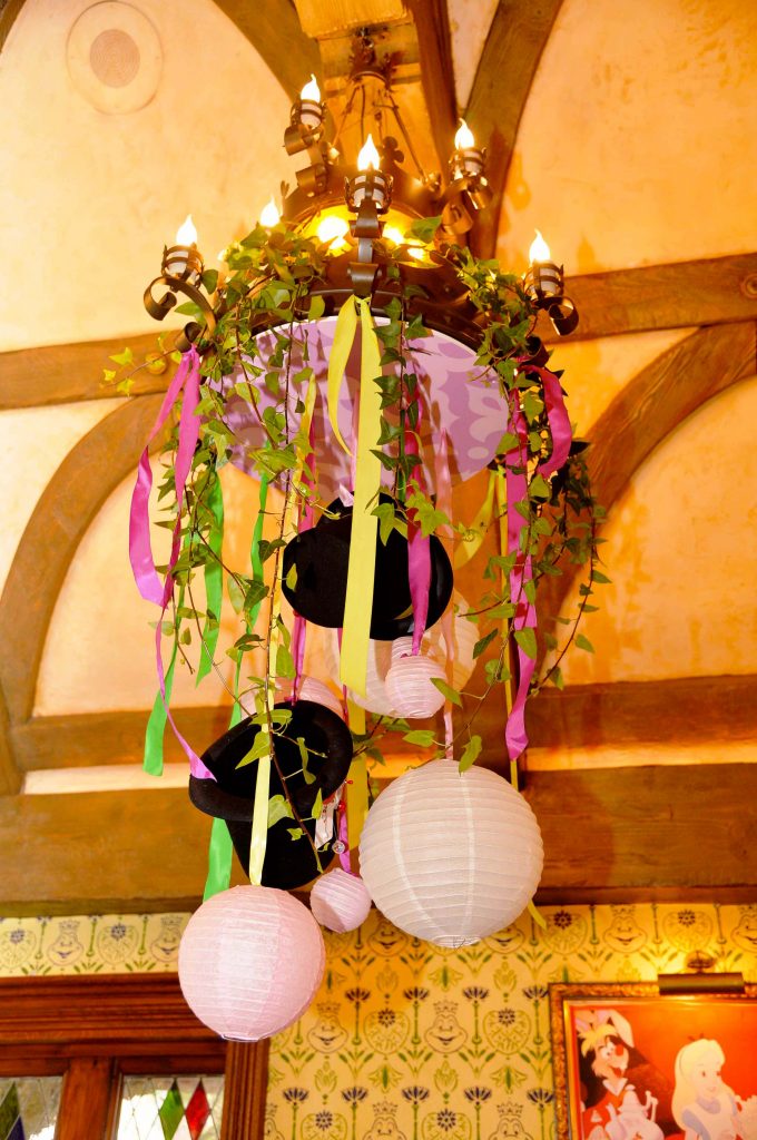 décoration événementiel d'un lustre avec des chapeau sur le thème Alice aux pays des merveilles